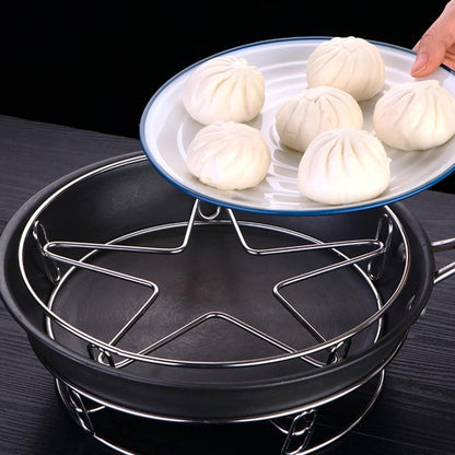 Stainless steel pot rack by THE GIR FARMER holding a star-shaped steamer rack inside a black pot with steamed buns on a plate