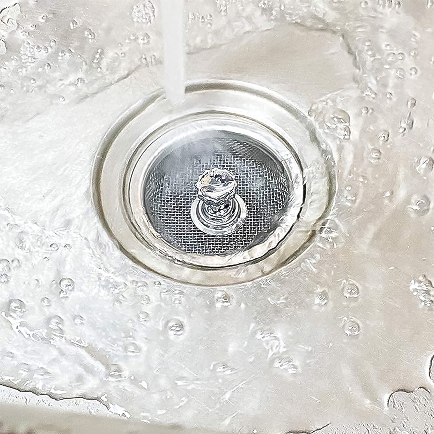 Your Brand stainless steel sink strainer in action, filtering water in a kitchen sink