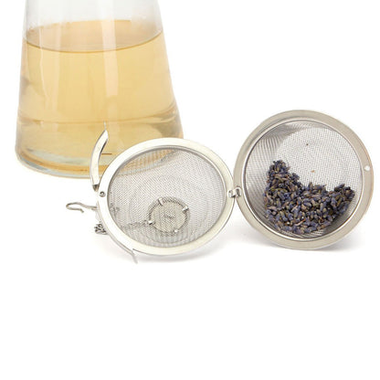 Your Brand stainless steel tea filter with loose lavender tea and a glass teapot