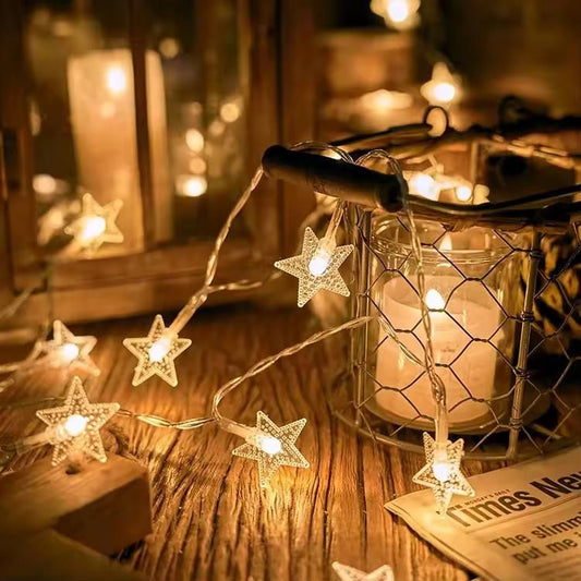 Star string lights for decoration illuminating a cozy scene with a candle and wooden surroundings