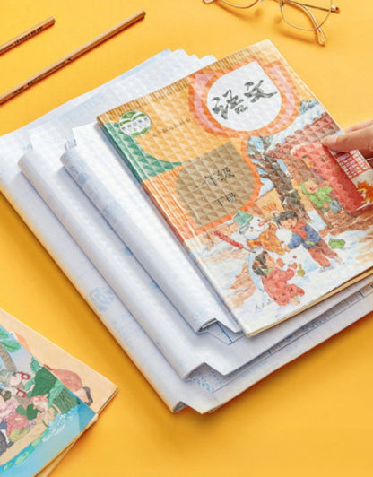 Transparent book cover pack protecting colorful illustrated books stacked on a yellow background