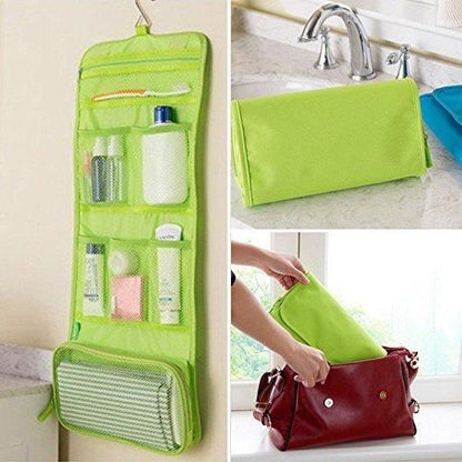 Green travel makeup organizer bag with multiple compartments hanging and being packed into a red handbag
