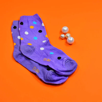 Trendy printed socks in purple with colorful polka dots on an orange background