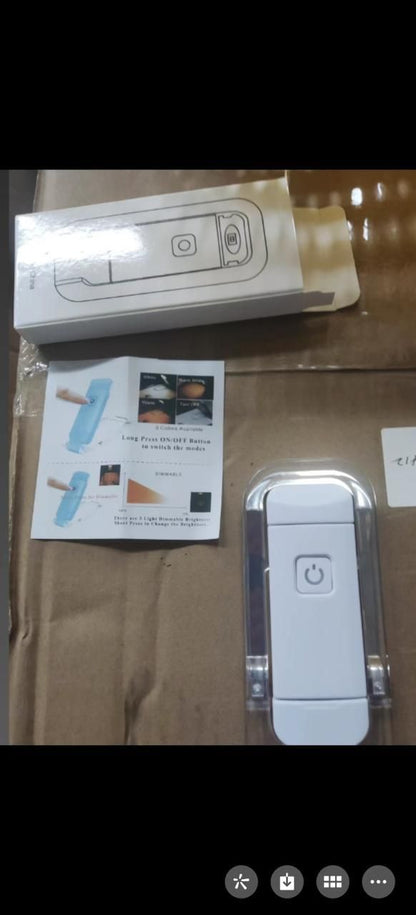 White usb rechargeable reading light with power button and packaging on a brown surface