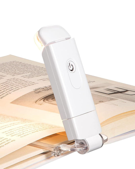 White usb rechargeable reading light clipped to an open book for hands-free reading