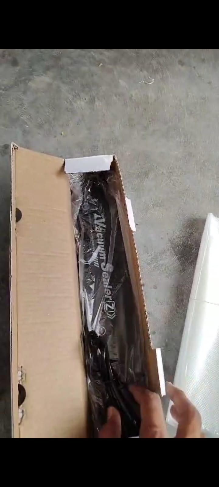 Unboxing the vacuum sealer machine for food preservation in its original packaging
