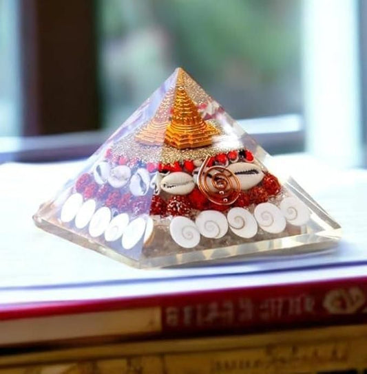Crystal wealth pyramid for home with decorative gold spiral and embedded shells on a table
