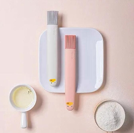 THE GIR FARMER silicone pastry brush set in gray and pink with soft bristles on white plate with baking ingredients