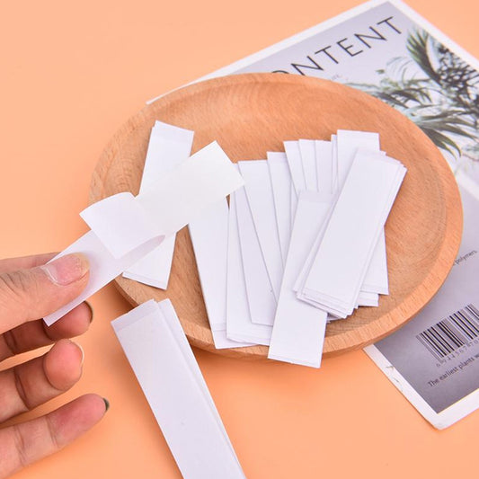Assorted pieces of waterproof medical tape for lingerie displayed in a wooden bowl on an orange background