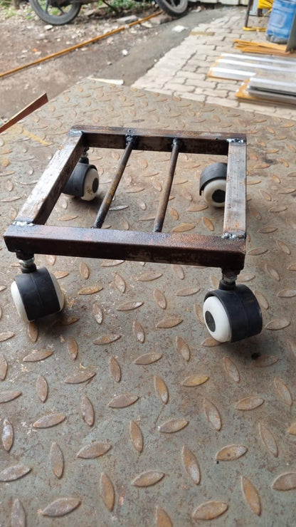 Metal wheel pot stand for planters with four black caster wheels on a textured floor
