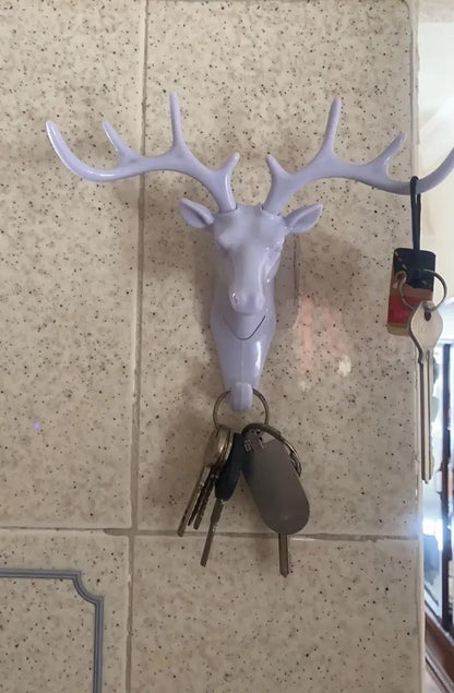 White deer head self adhesive coat hook mounted on tile wall holding keys