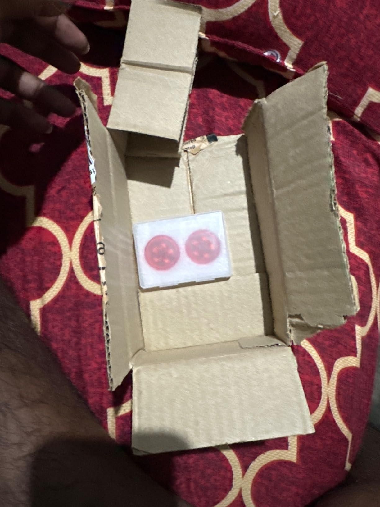 Open cardboard box containing wireless car door warning lights in protective packaging