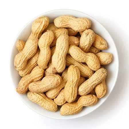 Bowl of brown organic groundnuts with shell, perfect for snacking or baking recipes